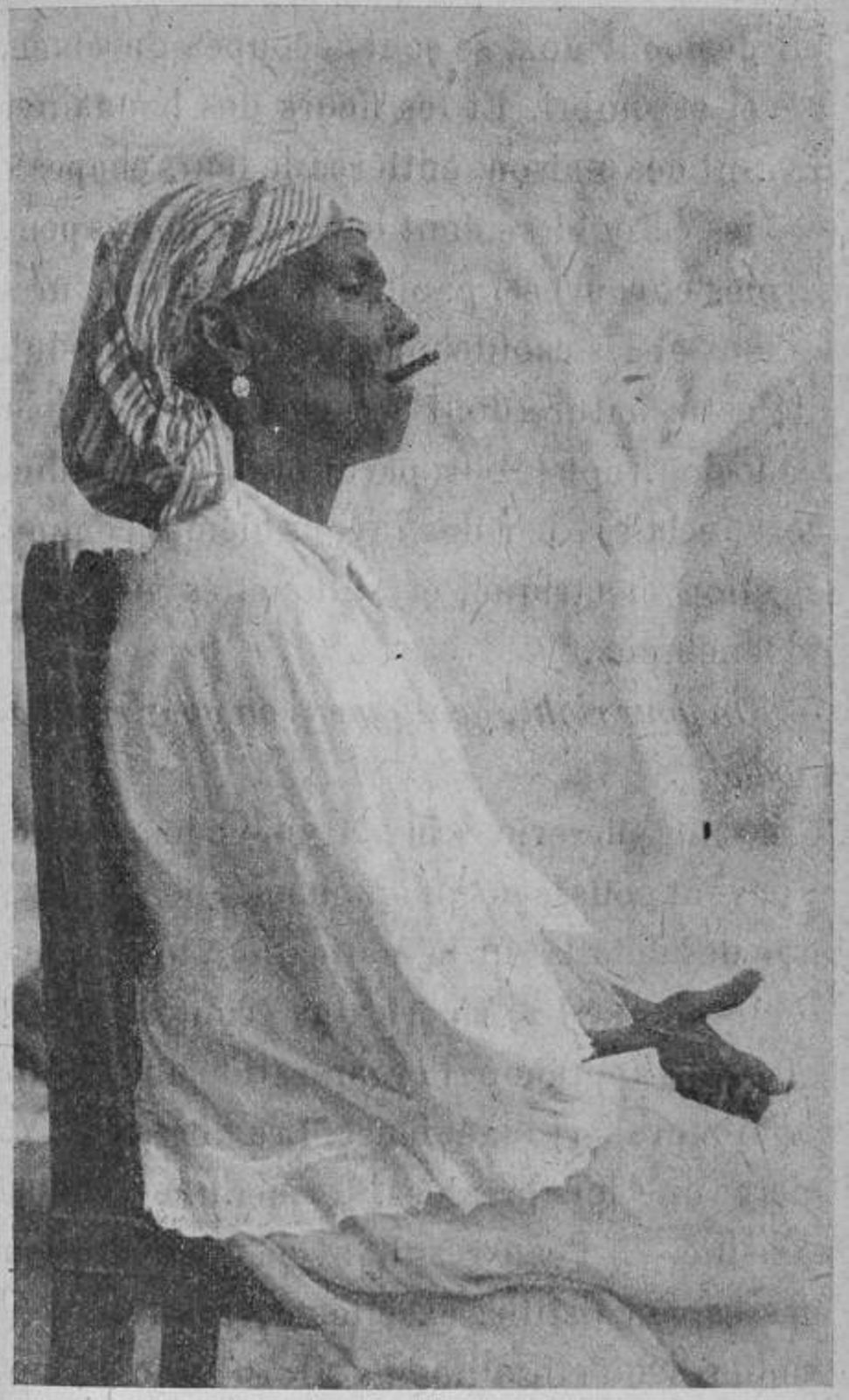 Cuban woman sitting in a chair and smoking a cigarette